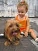 Little girl sitting on the ground with a dog