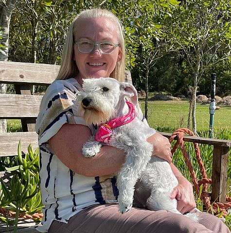 The dog breeder holding a white miniature schnauzer